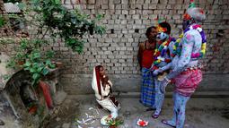 Seorang wanita (kiri) berdoa dihadapan sejumlah umat hindu yang mengecat tubuhnya selama ritual dalam festival keagamaan Siwa Gajan di Bengal Barat , India , (11/4).Kegiatan ini juga menandai akhir tahun kalender Bengali. (REUTERS / Rupak De Chowdhuri)