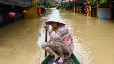 Seorang perempuan mendayung perahu di jalanan yang terendam banjir setelah hujan deras di Hoi An, Vietnam, Kamis 30 Oktober 2025. Hujan deras dengan intensitas tertinggi sepanjang sejarah memicu banjir besar di Vietnam bagian tengah. (NHAC NGUYEN/AFP)