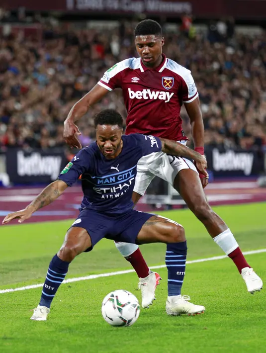 Pemain Manchester City Raheem Sterling (depan) memperebutkan bola dengan pemain West Ham United Ben Johnson pada pertandingan Piala Liga Inggris di London Stadium, London, Inggris, 27 Oktober 2021. Manchester City kalah lewat adu penalti. (AP Photo/Ian Walton)
