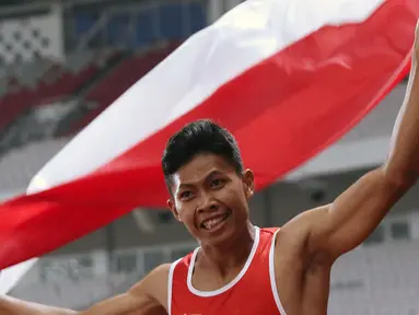 Atlet para-atletik Indonesia, Sapto Yogo Purnomo merayakan kemenangan lari nomor 100 meter T37 pria yang digelar di Stadion GBK, Jakarta, Selasa (9/10). Ini menjadi medali emas kedua Sapto di Asian Para Games 2018. (Liputan6.com/Helmi Fithriansyah)