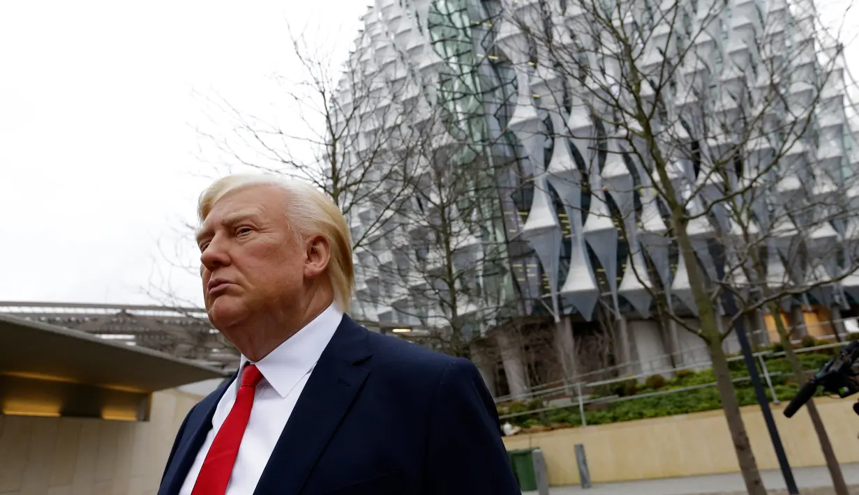 Lilin Madame Tussauds Presiden AS Donald Trump dengan latar belakang gedung Kedutaan Besar AS yang baru di Nine Elms, London (12/1). Trump juga menyatakan ia tidak menyukai lokasi Kedutaan Besar AS yang baru. (AP Photo / Alastair Grant)