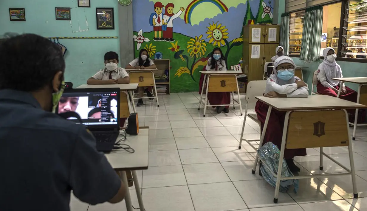Siswa mengikuti pembelajaran tatap muka (PTM) di sebuah sekolah di Surabaya, Jawa Timur, Senin (6/9/2021). Pemerintah kembali membuka sekolah di tengah pandemi COVID-19. (JUNI KRISWANTO/AFP)