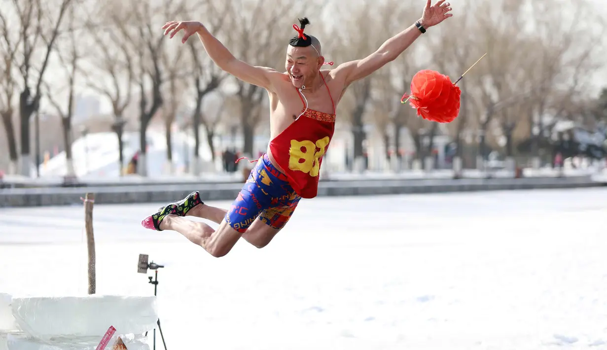 Seorang pria saat melompat ke danau yang beku di Shenyang di provinsi Liaoning, China timur laut (2/3). (AFP Photo)