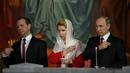 Presiden Rusia Vladimir Putin (kanan) bersama Perdana Menteri Rusia Dmitry Medvedev (kiri) dan istrinya Svetlana saat menjalani prosesi Paskah Ortodoks di Gereja Katedral Kristus Juru Selamat di Moskow, Rusia,(16/4). (AFP Photo / Vasily Maximov)