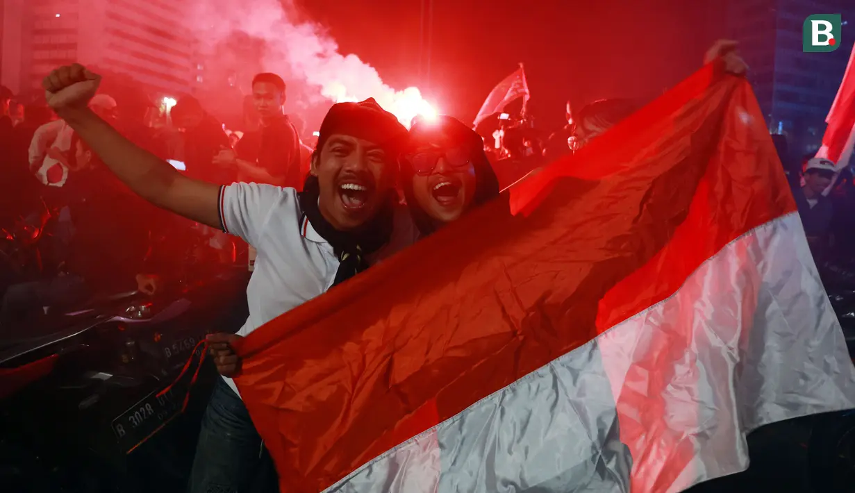 Selebrasi suporter Timnas Indonesia saat berkumpul di Bundaran Hotel Indonesia (HI), Selasa (16/5/2023). Kedatangan mereka untuk merayakan keberhasilan Timnas Indonesia U-22 di SEA Games 2023 setelah 32 tahun lamanya tidak pernah merasakan meraih medali emas ajang bergengsi di ASia Tenggara tersebut. (Bola.com/M Iqbal Ichsan)