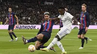 Bek Barcelona, Ronald Araujo menahan tembakan yang dilepaskan winger Real Madrid, Vinicius Junior dalam leg pertama semifinal Copa Del Rey 2022/2023, 2 Maret 2023. (AFP/Oscar Del Pozo)
