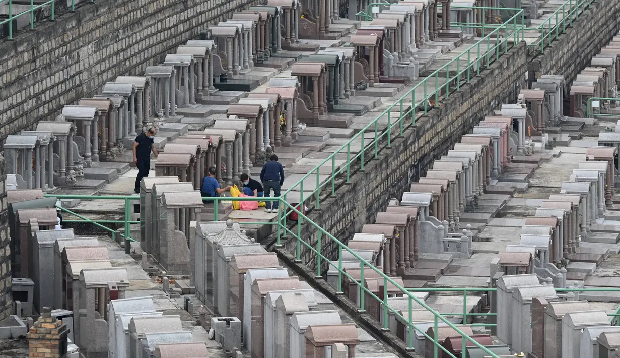 Orang-orang mengunjungi Pemakaman China Cape Collinson untuk memberi penghormatan kepada orang tercinta yang telah meninggal di dekat Chai Wan, Hong Kong, 5 April 2021. Kegiatan ini untuk menandai Festival Ching Ming yang juga dikenal sebagai pembersihan makam. (Peter PARKS/AFP)