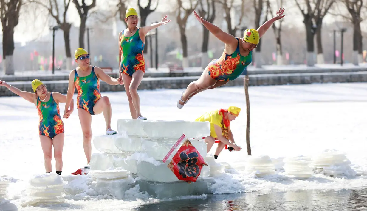 Seorang wanita  melompat ke danau yang beku di Shenyang di provinsi Liaoning, China timur laut (2/3). (AFP Photo)