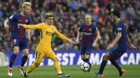 Striker Atletico Madrid, Antoine Griezmann, berusaha melewati kepungan pemain Barcelona pada laga La Liga Spanyol di Stadion Camp Nou, Barcelona, Minggu (4/3/2018). Barcelona menang 1-0 atas Atletico. (AFP/Lluis Gene)
