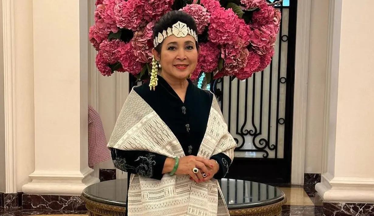 Ia juga tampil dengan selandang dan bawahan kain ulos warna abu-abu dipadukan atasan baju kurung hitam. Lengkap dengan hiasan kepala khas Batak. [@titieksoeharto]