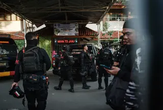 Hingga kini, pihak kepolisian terus menyelidiki penyebab ledakan di SMAN 72 Jakarta tersebut. Tampak dalam foto, petugas kepolisian dari Korps Brimob berkumpul di pintu masuk SMAN 72 Jakarta pada Jumat 7 November 2025. (YASUYOSHI CHIBA/AFP)