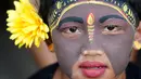 Seorang pemuda berpartisipasi dalam ritual Hindu "Grebeg" di Desa Tegallalang, Bali, Rabu (30/1). Dalam ritual dua tahunan ini, para pemuda berkeliling kampung dengan riasan tubuh warna-warni untuk menangkal Roh jahat. (AP/Firdia Lisnawati)