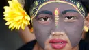Seorang pemuda berpartisipasi dalam ritual Hindu "Grebeg" di Desa Tegallalang, Bali, Rabu (30/1). Dalam ritual dua tahunan ini, para pemuda berkeliling kampung dengan riasan tubuh warna-warni untuk menangkal Roh jahat. (AP/Firdia Lisnawati)