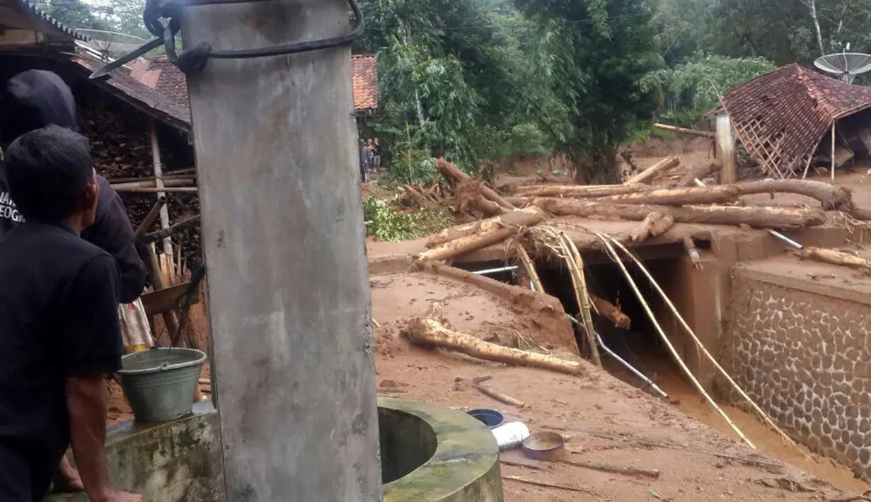 Warga memperhatikan pemukiman yang terkena banjir material longsor di Desa Pasir panjang, Salem, Brebes, Jawa Tengah, Jumat (23/2). Puluhan rumah hancur dan penuh lumpur akibat terkena material longsor bukit Gunung Lio. (AP Photo)