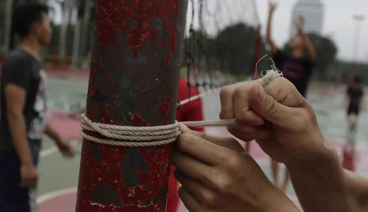 Warga mengikat jaring net saat olahraga voli di Kawasan Monumen Nasional, Jakarta, Rabu (13/2). Monas merupakan salah satu lokasi yang kerap dijadikan ruang olahraga bagi warga ibukota. (Bola.com/M. Iqbal Ichsan)