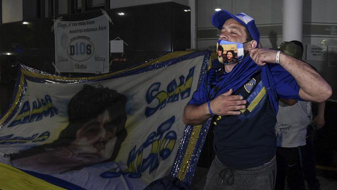 Penggemar mantan bintang sepak bola Argentina, Diego Maradona berkumpul di luar rumah sakit tempatnya akan menjalani operasi di Olivos, Buenos Aires, Selasa (3/11/2020). Diego Maradona menjalani operasi hematoma subdural atau pembekuan darah di otak. (JUAN MABROMATA / AFP)