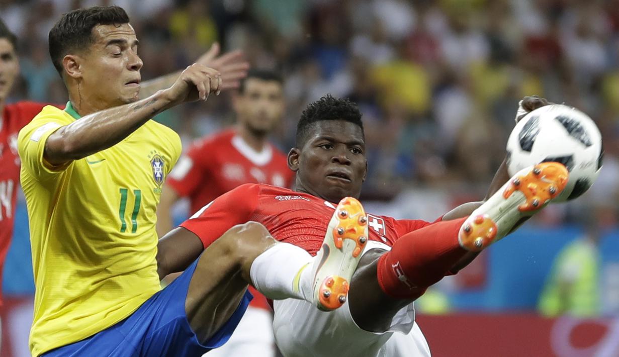 Gelandang Brasil, Philippe Coutinho, berebut bola dengan striker Swiss, Breel Embolo, pada laga Grup E Piala Dunia di Rostov Arena, Rostov-on-Don, Minggu (17/6/2018). Kedua negara bermain imbang 1-1. (AP/Andre Penner)