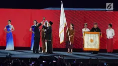 Gubernur DKI Jakarta Anies Baswedan menyerahkan obor Asian Games kepada Wali Kota Hangzhou China saat penutupan Asian Games 2018 di Stadion Utama GBK, Jakarta, Minggu (2/9). (Merdeka.com/Imam Buhori)