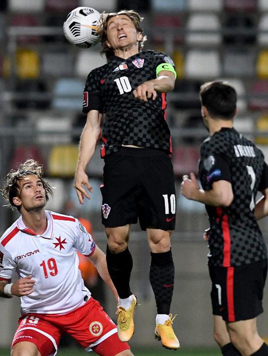 Pemain Kroasia Luka Modric (tengah) menyundul bola melewati pemain Malta Bjorn Kristensen (kiri) pada pertandingan Grup H kualifikasi Piala Dunia 2022 di Stadion Rujevica, Rijeka, Kroasia, Selasa (30/3/2021). (Denis LOVROVIC/AFP)