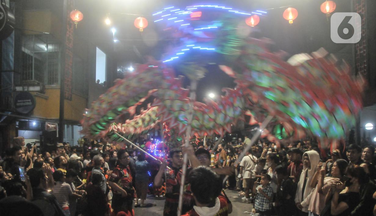 Warga menyaksikan pawai Liong dan Barongsai saat perayaan Cap Go Meh di Jalan Surya Kencana, Bogor, Jawa Barat, Minggu (5/2/2023). Pemkot Bogor kembali menggelar perayaan Cap Go Meh setelah 3 tahun ditiadakan akibat pandemi Covid-19. (merdeka.com/Iqbal S Nugroho)