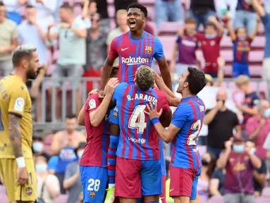 Ansu Fati yang tampil untuk pertama kali bagi Barcelona langsung menorehkan namanya di papan skor saat timnya mengalahkan Levante 3-0. Sontak seluruh pemain langsung menghampiri dan mengangkatnya layaknya seorang raja. (AFP/Lluis Gene)