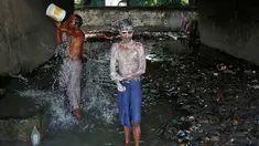Dua laki-laki mandi di bawah sebuah jembatan di daerah kumuh di Kalkuta, India (26/5/2016). Kalkuta adalah salah satu kota pelabuhan penting di India yang merupakan ibu kota Benggala Barat. (REUTERS/Rupak De Chowdhuri)
