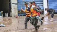 Polisi paramiliter mengevakuasi seorang penduduk setelah banjir yang disebabkan oleh hujan lebat di Chongqing barat daya China pada 4 Juli 2023. (STR/AFP)