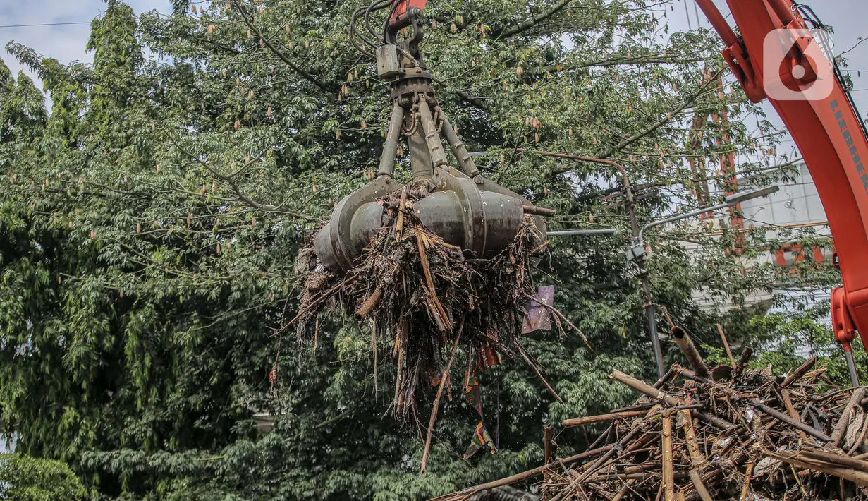 Pekerja kebersihan mengangkat sampah yang menumpuk di pintu air Manggarai, Jakarta, Selasa (22/9/2020). Tingginya curah hujan membuat kiriman sampah menumpuk di pintu air Manggarai. (Liputan6.com/Faizal Fanani)