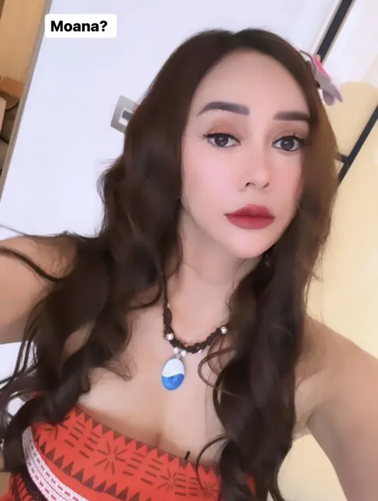 Melengkapi penampilan dengan aksesori kalung berliontin biru. Dengan rambut panjang bergaya wave tanpa poni mengenakan hair clip. Wajahnya dipoles dengan blush on pink tips, lipstik matte, dan eyeshadow coklat. [@aurakasih]