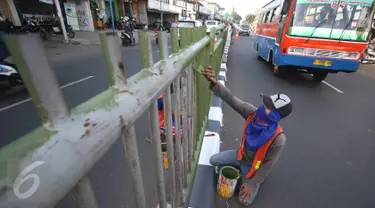 Pekerja mengecat pagar pembatas jalan di kawasan Pasar Minggu, Jakarta Selatan, Rabu (26/10). Pengecatan dilakukan sebagai bentuk perawatan agar pagar pembatas tetap rapi dan tidak tampak kusam. (Liputan6.com/Immanuel Antonius)