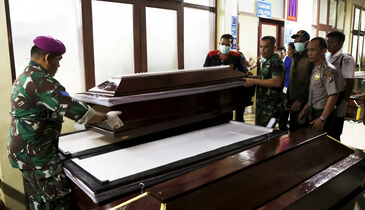 Petugas mempersiapkan puluhan peti mati di depan instalasi jenazah RSUP Adam Malik, Medan, Selasa (30/6/2015). Sebanyak 141 jenazah korban jatuhnya pesawat Hercules C130 berhasil dievakuasi ke rumah sakit tersebut. (REUTERS/Beawiharta)