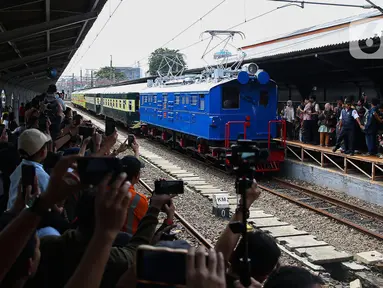 Warga menyaksikan rangkaian lokomotif listrik ESS 3200 tahun pembuatan 1927 saat memasuki peron pada perayaan 100 tahun operasional Kereta Rel Listrik (KRL) di Stasiun Jakarta Kota, Selasa (22/4/2025). (Liputan6.com/Angga Yuniar)