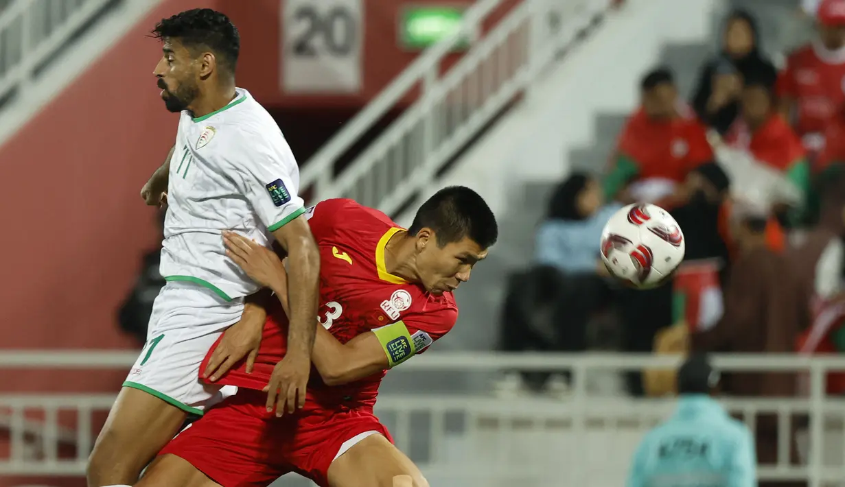 Striker Timnas Oman, Muhsen Al Ghassani (kiri) berebut bola dengan bek Kirgistan, Tamirlan Kozubaev pada laga ketiga Grup F Piala Asia 2023 di Abdullah bin Khalifa Stadium, Doha, Qatar, Kamis (25/1/2024). (AFP/Karim Jaafar)