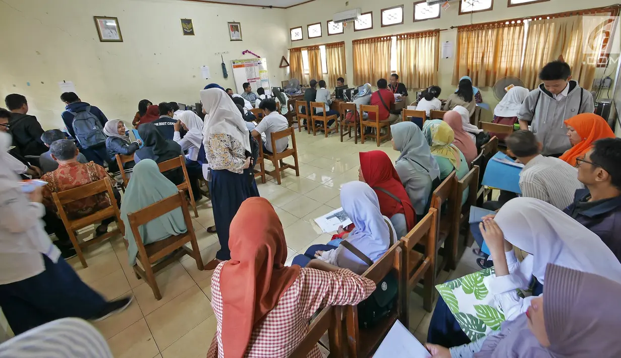 Suasana saat para siswa dan orangtua murid mengikuti seleksi Penerimaan Peserta Didik Baru (PPDB) di SMAN 1 Depok, Kota Depok, Jawa Barat, Selasa (18/6/2019). PPDB SMA dibagi menjadi tiga jalur yakni zonasi, prestasi, dan pemindahan orangtua. (Liputan6.com/Herman Zakharia)