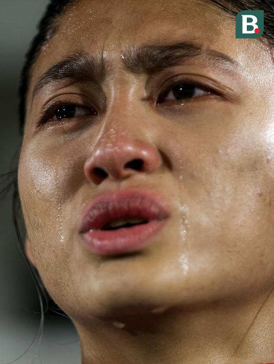 Pemain Timnas Indonesia Putri, Zahra Muzdalifah tak mampu menahan air mata saat menyanyikan lagu kebangsaan Indonesia Raya sebelum laga persahabatan melawan Singapura di Stadion Madya, Senayan Jakarta, Selasa (28/05/2024). (Bola.com/Bagaskara Lazuardi)