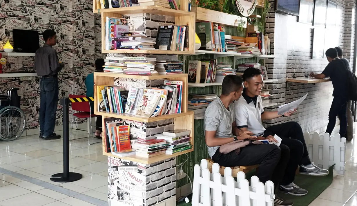 Warga menunggu pembuatan Surat Keterangan Catatan Kepolisian (SKCK) dengan membaca di perpustakaan mini di Mapolres Tangerang Selatan, Banten, Kamis (5/7). Selain memberi rasa nyaman, hal ini juga untuk meningkatkan minat baca. (Merdeka.com/Arie Basuki)
