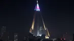 Pertunjukan cahaya menampilkan bendera Korea Utara di atas hotel Ryugyong di kota Pyongyang, Korea Utara (9/4). (AFP Photo/Ed Jones)