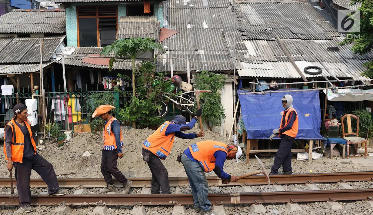 Pekerja menambahkan kerikil pada bantalan rel kereta di kawasan Roxy, Jakarta, Selasa (7/1). Penambahan kerikil tersebut dilakukan sebagai bentuk perawatan rutin agar perjalanan kereta tetap aman dan lancar. (Liputan6.com/Immanuel Antonius)