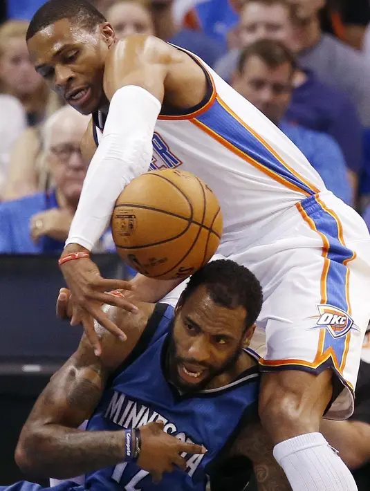 Aksi pemain Oklahoma City Thunder, Russell Westbrook (atas) melanggar pemain  Minnesota Timberwolves, Rasual Butler pada  laga NBA basketball preseason game di Oklahoma City, Senin (17/10/2016) WIB. (AP/Sue Ogrocki)