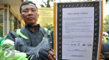 Perwakilan pengemudi ojek memperlihatkan deklarasi damai komunitas ojek pangkalan dengan komunitas ojek online di Polsek Kebun Jeruk, Jakarta (22/9/2015). Acara diselenggarakan unutk menjalin silaturahmi antar pengemudi ojek. (Liputan6.com/Gempur M Surya)