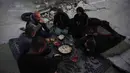 Mereka memasak dan makan di antara puing-puing bangunan, mencerminkan krisis kemanusiaan yang masih berlanjut. Tampak dalam foto, keluarga Suleiman berbuka puasa di bulan suci Ramadan di samping reruntuhan masjid, tempat mereka saat ini berlindung di Deir al-Balah, Jalur Gaza, Jumat 6 Maret 2026. (AP Photo/Abdel Kareem Hana)