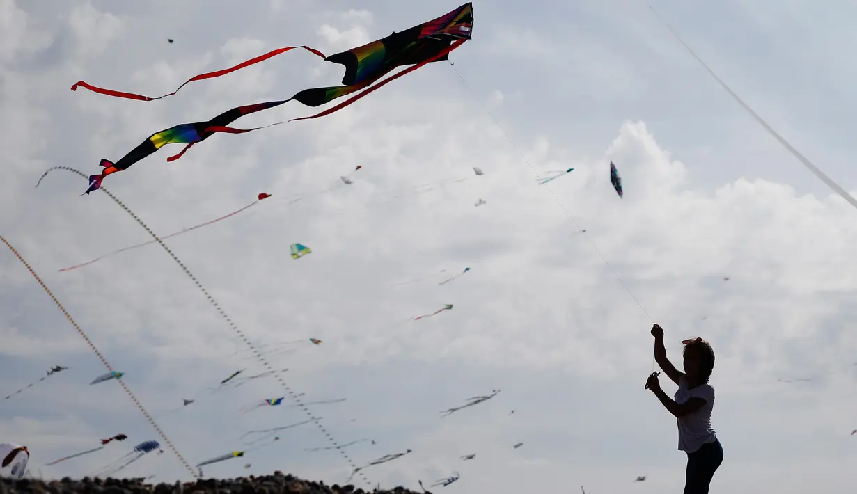 Seorang gadis menerbangkan layang-layang selama Festival Layang-layang Internasional Dieppe ke-20 di Dieppe, Prancis, Minggu (9/9). Festival setiap dua tahun sekali sejak 1980 itu menjadi festival layang-layang terbesar di Eropa. (AFP/CHARLY TRIBALLEAU)