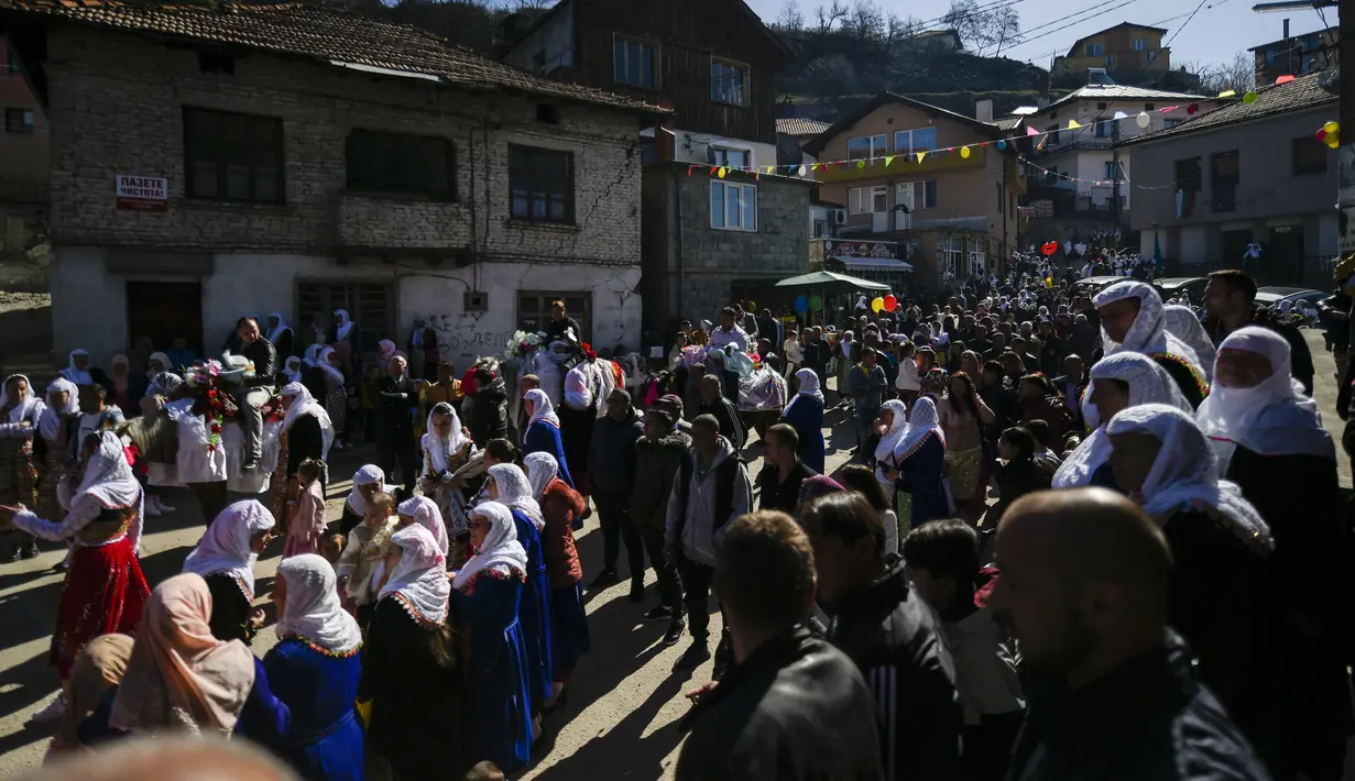 Pria Muslim Bulgaria menggendong putra mereka saat menunggang kuda selama upacara sunat massal untuk anak laki-laki di Desa Ribnovo, 11 April 2021. Penduduk Desa Ribnovo adalah muslim berbahasa Bulgaria, kadang-kadang disebut sebagai "Pomaks" atau "orang yang menderita". (Nikolay DOYCHINOV/AFP)