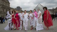 Model ukuran plus berpose di depan piramida Louvre di Paris, Prancis (4/1). Meraka melakukan catwalk di ruang publik dengan mengenakan busana layaknya di sebuah acara fashion show. (AFP/Thomas Samson)