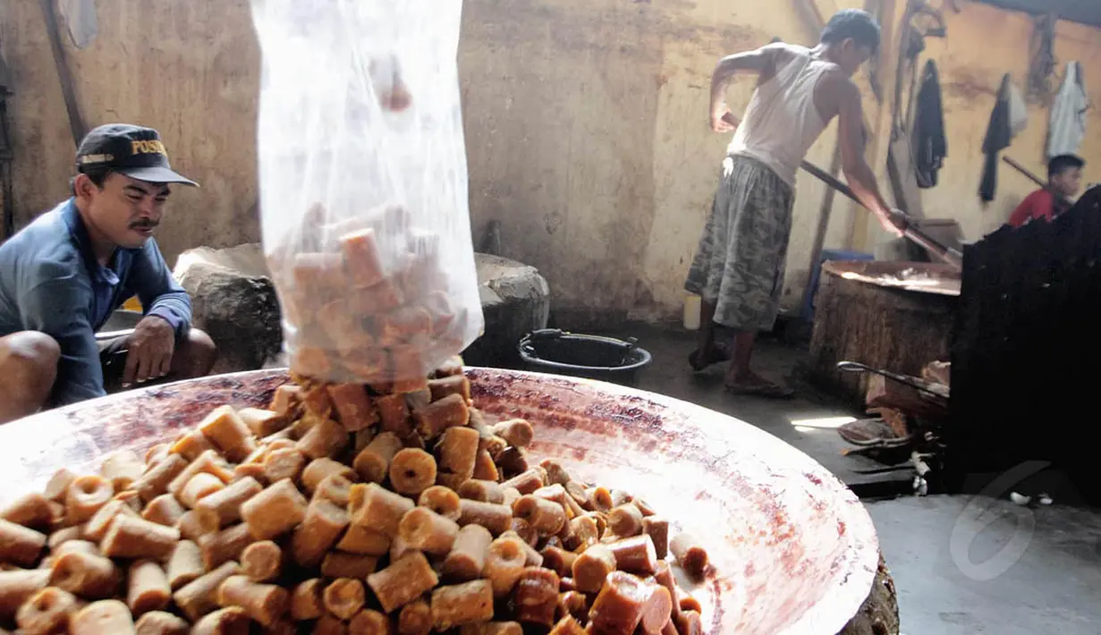 Pekerja dodol tampak memasukkan sejumlah gula merah ke dalam wadah besar, Jakarta, (16/7/14) (Liputan6.com/ Faizal Fanani)