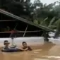 Amukan banjir yang kian parah hingga sekitar 4 meter membuat atap-atap rumah saja yang tersisa.