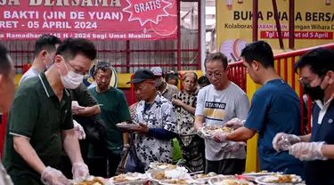 Para jemaat kelenteng Jin De Yuan membagikan makanan gratis kepada umat Muslim yang bersiap untuk berbuka puasa selama bulan suci Ramadan di Jakarta pada 18 Maret 2024. (Adek BERRY/AFP)