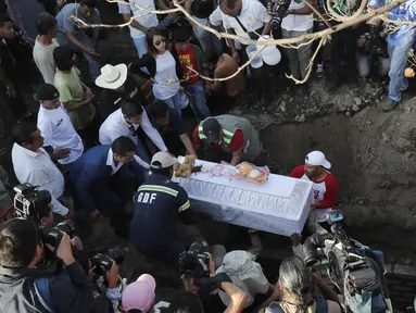 Anggota keluarga menguburkan korban pembunuhan Fatima berusia 7 tahun di Mexico City (18/2/2020). Jasad Fatima ditemukan terbungkus tas dan ditinggalkan di daerah pedesaan pada hari Sabtu. Lima orang telah diperiksa dan rekaman video penculikannya telah diamankan. (AP Photo/Marco Ugarte)