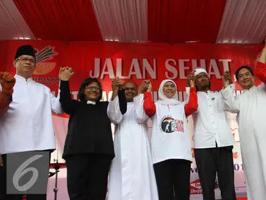 Menteri Sosial Khofifah Indar Parawansa berfoto bersama saat jalan sehat di Car Free Day, Bundaran HI, Jakarta, Minggu (6/11). Menjelang hari pahlawan Khofifah mengajak warga agar lebih mengingat jasa para pahlawan. (Liputan6.com/Gempur M. Surya)