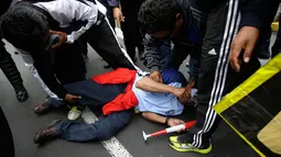 Seorang guru sekolah negeri tergeletak setelah tertembak peluru karet saat bentrokan dengan polisi di Lima, Peru, (24/8). Guru sekolah dari beberapa bagian negara Amerika Latin telah melakukan pemogokan selama 70 hari terakhir. (AP Photo / Martin Mejia)